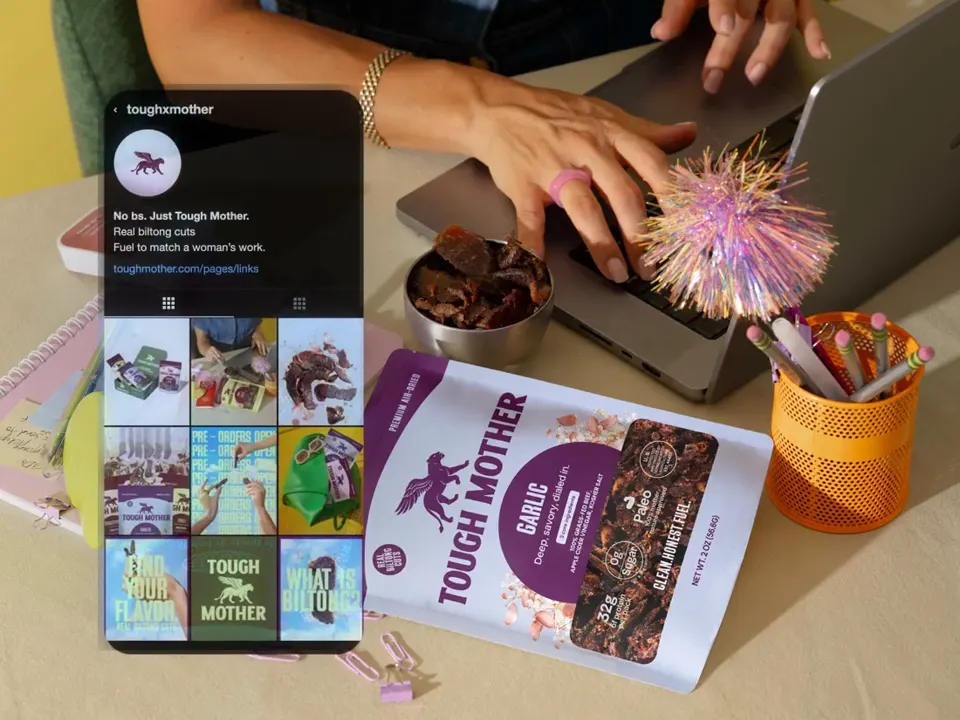 A customer at a cafe, with the Tough Mother Instagram grid, website and launch email floating beside her on phone screens